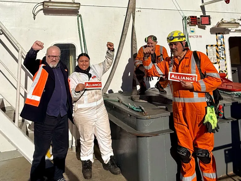 Maritime workers holding Alliance signs aboard a ship